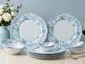 Bodhi house: Set of blue floral dinnerware on a table with flowers and a vase in the background.