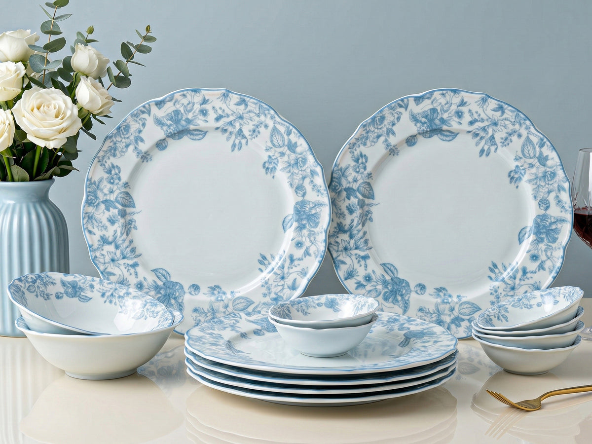 Bodhi house: Set of blue floral dinnerware on a table with flowers and a vase in the background.